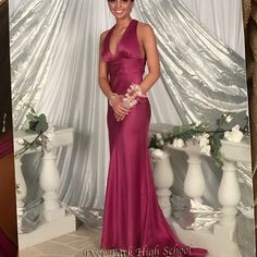 a woman in a long pink dress posing for a photo with flowers on her head