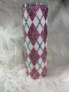 a pink and white plaid pattern tumbler cup with silver lid on a furry surface