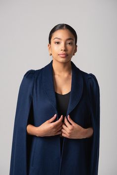 Our latest cape collection is made in a rich wool-cashmere blend, an ideal layering piece for all seasons. The Marina cape has a classic navy hue with a matching blue lining. The unique shoulder detail, a signature NN element in all our capes, creates a bold statement shoulder with the perfect silhouette. Marina is a timeless traditional cape. Add pearls, drape over a striped tee and denim for that classic coastal vibe. However you wear it, it will be uniquely yours and compliments are guarantee Elegant Wool Cape For Fall, Navy Elegant Wool Coat, Wool Cape For Formal Occasions, Navy Wool Elegant Coat, Formal Wool Cape Outerwear, Elegant Cashmere Winter Cape, Elegant Blue Wool Peacoat, Classic Winter Cape For Work, Classic Formal Cape For Fall