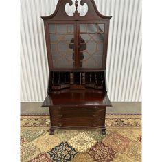 an antique wooden desk with glass doors and drawers