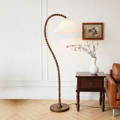 a living room with a couch, chair and lamp on the side table in front of it