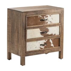 a brown and white cowhide drawer with three drawers on each side, against a white background