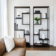 a living room filled with furniture and a book shelf next to a couch in front of a window