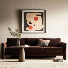 a living room with a couch, coffee table and painting on the wall