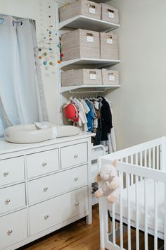 a baby's room with white furniture and lots of storage