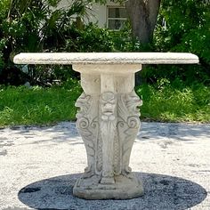 a stone table sitting on top of a cement slab