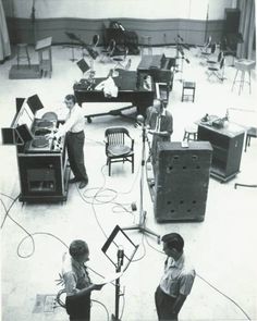 an old black and white photo of people recording