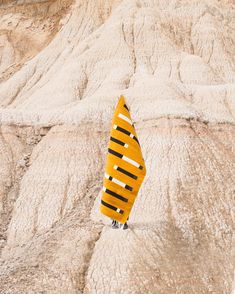 a yellow surfboard sticking out of the sand