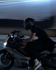 a man riding on the back of a motorcycle in front of a blurry background