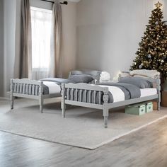 a bedroom with two beds and a christmas tree