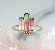 Three stone natural watermelon tourmaline ring. SOLD Similar can be made with other similar tourmalines. The design can be made with gemstones of your choosing. If you would prefer a custom ring, please contact us before purchase. Please take a look at our similar designs at the following links: https://www.etsy.com/listing/498675762/tourmaline-ring-diamond-engagement-ring https://www.etsy.com/listing/523459035/tourmaline-ring-diamond-engagement-ring Details; Main stone: bicolor watermelon tourm Watermelon Tourmaline Engagement Ring, Bijoux Art Deco, Pink Wedding Rings, Watermelon Tourmaline Ring, Baguette Engagement Ring, Tourmaline Engagement Ring, Ring Baguette, Ring Rosegold, Baguette Ring