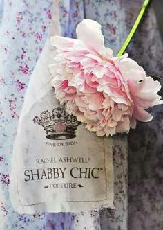 a pink flower in a paper bag with the label shabby chic