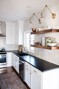 the kitchen is clean and ready for us to use it's counters are white with black counter tops