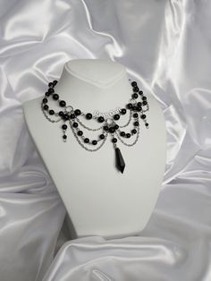 "Black Pearl Necklace, Gothic Jewelry, Witchy Choker, Unique Layered Necklace. Designed and made by me. 😺 All my designs are handmade. You can contact me for personalization. 🤍 - Pearl beads are glass. Black pendant is acrylic. - Necklace length is 40-41 cm / 16\" and adjustable.  - Stainless, nickel free. High quality brass material.  - I dont use any animal products such as real pearls or leather in my products. Totally vegan. - And also I use 100% recyclable packaging materials. You can message me here (Etsy messages) and on my Instagram account @Raven.Craft.Y with your requests, questions, ask for help or personalization. - To check my all models, you can visit my page 🖤 https://www.etsy.com/shop/RavenCraftByYesim" Gothic Chokers Collars, Black Layered Necklace, Dark Fairy Necklace, Gothic Beaded Jewelry, Gothic Beaded Necklace, Gothic Accessories Jewellery, Dark Accessories, Gothic Jewelry Diy, Witch Accessories