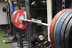 a gym filled with lots of different colored barbells