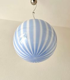 a blue and white striped light fixture hanging from a ceiling in a home or office