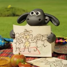 a cartoon sheep holding up a sign with two children's drawings in front of it