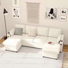 a living room with white furniture and pictures on the wall