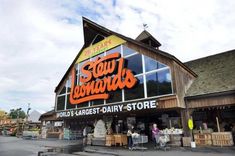 people are standing in front of a store with large windows that read slow forward's world's largest dairy store