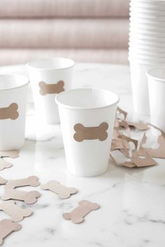 white cups with brown dog bone decals on them