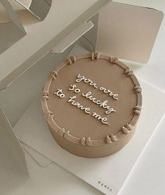 a chocolate cake sitting on top of a white table next to a piece of paper