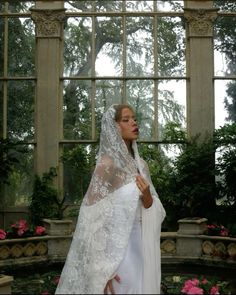 a woman in a white wedding dress and veil