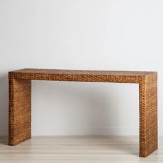 a wooden bench made out of wicker sitting on top of a hard wood floor