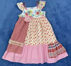 a dress made out of different fabrics on a blue background with pink and white polka dots