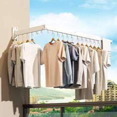 clothes hanging on rail in front of window with cityscape and blue sky behind