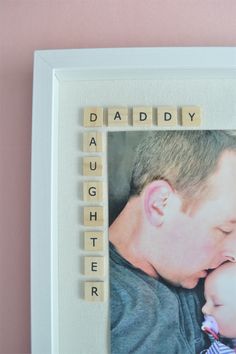 a photo frame with scrabble letters that spell out the words daddy and daughter