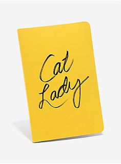 a yellow notebook with the words cat lady written on it in cursive writing