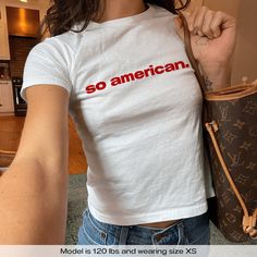 "So American 4th Of July USA" Graphic Slogan Printed On Aesthetic Retro Vintage 90s Y2k Baby Tee Shirt with our own unique font.  🎨 Available in White, Light Pink, Light Blue, Navy, Black. If you need a different color, please let us know! (Ash, Red, Sport Grey & Green)  🎁 Our baby tees are perfect gift for her or him offering timeless fashion and versatility that anyone will cherish. Baby tees, popular in the '90s, have short sleeves and a slightly cropped body, giving a flattering feminine s Unisex Summer Top With Logo Print, Unisex Y2k White Top, Unisex White Y2k Style Tops, White Unisex Y2k Style Tops, Y2k Unisex White Top, Y2k Streetwear Pre-shrunk Tops, Unisex Basic Tops For Streetwear, White Y2k Pre-shrunk Tops, Y2k Fitted Cotton Shirt