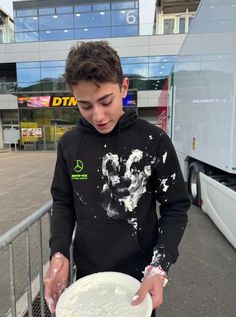 a young man holding a white frisbee in his hand