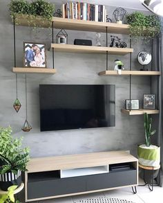 a living room with shelves and a flat screen tv mounted on it's wall