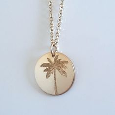 "Enjoy a bit of tropical summer with this beautifully engraved palm tree necklace. You can have this in 14k gold fill, 14k rose gold fill or sterling silver. The backside can be engraved with a hidden message of your choice. Simply select \"personalize\" in the drop down menu upon checking out and leave me a message in the note field with what you would like to have engraved. I use arial font by default unless otherwise specified. Disc pendant is 16mm in diameter." Etched Round Rose Gold Jewelry, Beach Pendant Jewelry With Engraving, Beach Engraved Pendant Jewelry, Engraved Pendant Necklace For Beach, Adjustable Engraved Necklaces For Beach, Adjustable Engraved Necklaces For The Beach, Rose Gold Sterling Silver Laser Engraved Necklaces, Minimalist Laser Engraved Pendant Jewelry, Engraved Gold Beach Jewelry