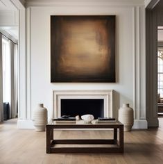 a living room filled with furniture and a large painting on the wall over a fire place