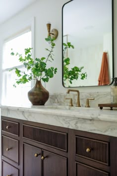 a bathroom with marble counter tops and wooden cabinets, along with a large mirror above the sink