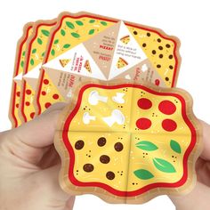 a hand holding four pieces of pizza shaped like an origami box with different toppings