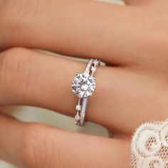 a woman's hand with a diamond ring on it