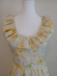 This is a really lovely 1970s maxi-dress with ruffled neckline, empire waistline and slight flared skirt and ruffled hem. It appears handmade. The fabric is a cream colored sheer organza with a flocked daisy print over white cotton. There is a zipper and single snap in the back. Bust - 32"  Waist - 28" Hips - 50" measured 15" below armpit  Length - 56" from shoulder to hem Condition - Very Good.  I'm estimating this to fit an Extra Small to Small size. The dress fit on my dressform which has a 34" bust, 26" waist, and 33" hips. The fabric does not stretch. This will be long on petites. ** On Sale! Originally $85, now reduced to $70 ** Feminine A-line Vintage Dress With Ruffles, Fitted A-line Vintage Dress With Ruffles, Summer Garden Party Dress With Ruffled Collar, Fitted Sundress With Gathered Neckline, Fitted Sundress Maxi Dress With Gathered Neckline, Empire Waist Dresses With Ruffles For Garden Party, Garden Party Dresses With Ruffles And Empire Waist, Garden Party Dresses With Empire Waist And Ruffles, Fitted Dress With Empire Waist And Ruffle Hem