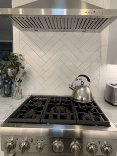 a stove top oven sitting inside of a kitchen next to a pot on the burner