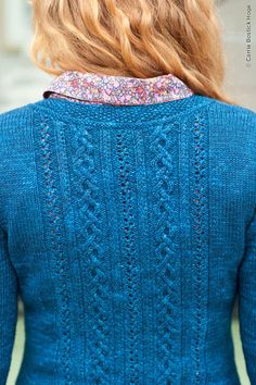 the back of a woman's blue sweater