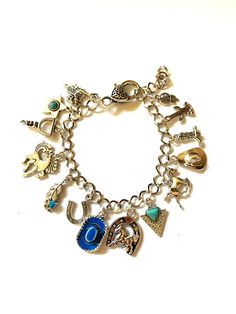 "Western silver color curb chain charm bracelet. Has 14 charms; Cactus, Spur, Silver Cowboy Hat, Blue Cowboy Hat, Horseshoe, Galloping Horse, Prancing Horse, Feather with Turquoise Accent, Arrow Point with Turquoise Accent, Cowboy Boot, Saddle, Horseshoe with Horse, Dreamcatcher & Star with Turquoise center. Adjustable length from 7\" - 9\".  Great to wear with that western outfit or to the rodeo! Thank you for stopping by" Horse Prancing, Blue Cowboy Hat, Silver Cowboy Hat, Prancing Horse, Arrow Point, Chain Charm Bracelet, Galloping Horse, Western Outfit, Turquoise Accents