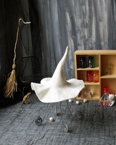 a white chair sitting on top of a floor next to a shelf