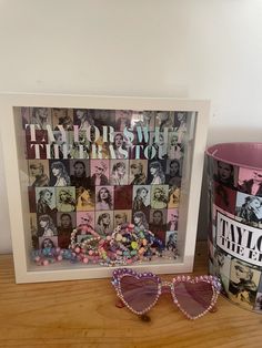 a pair of sunglasses sitting on top of a wooden table next to a pink cup