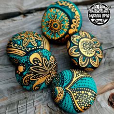 four painted rocks sitting on top of a wooden table