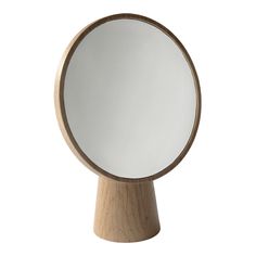 a round mirror sitting on top of a wooden stand