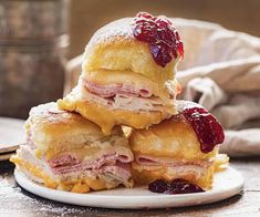 three pastries stacked on top of each other with cranberry sauce and powdered sugar