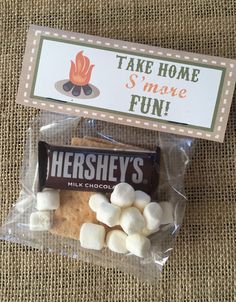 there is a bag of marshmallows on the ground next to a sign that says take home s'more fun