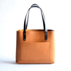 Leather tote bags are a classic accessory that stand the test of time. Our totes are versatile, practical, and classic, making them a must-have addition to any wardrobe. She's a versatile accessory that can be used for a range of purposes, from carrying your laptop to the office to carrying groceries...plus so much more! This bag is built to last!Honey LeatherBlack Leather StrapsBrass Hardware Top 10 Reasons Classic Leather Totes are Must-Haves ... • Fast & FREE Shipping on orders over $150• Mad Classic Leather Tote, Leather Tote Bags, Leather Totes, Key Clip, Tote Bag Leather, Zipper Top, 10 Reasons, Leather Zipper, Open Top